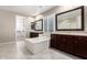 The bathroom is equipped with a soaking tub and dual vanities with marble countertops at 9382 W Louise Dr, Peoria, AZ 85383