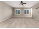 Bedroom with neutral carpet, ceiling fan, and bright windows at 9382 W Louise Dr, Peoria, AZ 85383