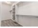 Walk-in closet offering built in shelving units and neutral carpeting at 9382 W Louise Dr, Peoria, AZ 85383