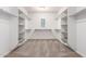 Spacious walk-in closet featuring white shelving units and neutral carpet at 9382 W Louise Dr, Peoria, AZ 85383