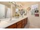 Bathroom featuring double sinks, a large mirror with ivy accents, and a shower with white curtain at 947 N Saffron --, Mesa, AZ 85205