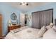 Bedroom with blue walls, ceiling fan, bed and dresser, closet with patterned curtain at 947 N Saffron --, Mesa, AZ 85205