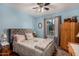 Bedroom featuring blue walls, ceiling fan, a bed with throw pillows, and a wood dresser at 947 N Saffron --, Mesa, AZ 85205