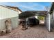 A spacious carport sheltering a boat and a trailer, with a storage building and various items in the background at 947 N Saffron --, Mesa, AZ 85205