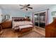 Cozy main bedroom featuring light blue walls, ceiling fan, and sliding glass door leading outside at 947 N Saffron --, Mesa, AZ 85205