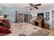 Main bedroom with blue walls, ceiling fan and a writing desk next to a sliding glass door at 947 N Saffron --, Mesa, AZ 85205