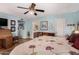 Light blue bedroom with ceiling fan, floral bedding, writing desk and bathroom access at 947 N Saffron --, Mesa, AZ 85205