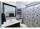 Stylish bathroom with decorative shelving, vanity and black and white shower curtain provides a comfortable and functional space at 949 E Piute Ave, Phoenix, AZ 85024