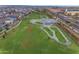 An aerial view shows a neighborhood park with a skate park, grassy area, and walking paths near residential homes at 9730 E Resistance Ave, Mesa, AZ 85212