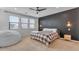 Comfortable bedroom with a black accent wall, three windows, and a cozy beanbag chair at 9730 E Resistance Ave, Mesa, AZ 85212