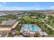 Aerial view of a community pool with palm trees, lounge chairs, and a modern building nearby at 9730 E Resistance Ave, Mesa, AZ 85212