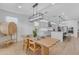 Bright dining room features a wood table, modern chandelier, and kitchen in the background at 9730 E Resistance Ave, Mesa, AZ 85212