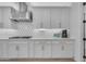 Modern kitchen featuring white cabinets, stainless steel hood, and contrasting backsplash at 9730 E Resistance Ave, Mesa, AZ 85212