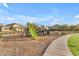 Playground with modern play equipment, a walking path, and well-maintained landscaping in a residential community at 9730 E Resistance Ave, Mesa, AZ 85212