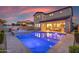 Backyard view featuring a pool and covered patio with outdoor seating at dusk at 9730 E Resistance Ave, Mesa, AZ 85212