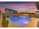 Backyard pool and spa illuminated, surrounded by low-maintenance landscaping, offering a serene outdoor escape at 9730 E Resistance Ave, Mesa, AZ 85212