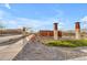 Streetscape featuring decorative columns, lush desert landscaping, and sidewalks within a residential community at 9730 E Resistance Ave, Mesa, AZ 85212