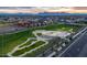 Aerial view of a neighborhood with a skate park, grassy areas, and mountain views in a Primary-planned community at 9759 E Satellite Dr, Mesa, AZ 85212