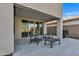 Covered back patio with sliding glass doors, modern outdoor furniture, and views of the beautifully landscaped backyard at 9759 E Satellite Dr, Mesa, AZ 85212