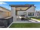 Modern outdoor kitchen under a covered patio, complete with a bar, seating, a built-in grill, and ceiling fan at 9759 E Satellite Dr, Mesa, AZ 85212