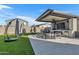 Stylish covered outdoor kitchen featuring a TV, fireplace, bar area, and comfortable seating for entertainment at 9759 E Satellite Dr, Mesa, AZ 85212