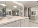 Bathroom vanity with double sinks, large mirrors, and sliding door closet at 9837 E Michigan Ave, Sun Lakes, AZ 85248