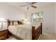 Cozy bedroom features a wood bed frame, ceiling fan, and bright natural light from the window at 9837 E Michigan Ave, Sun Lakes, AZ 85248