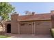 This home features a charming brown two-car garage with decorative windows and a red tile roof at 9837 E Michigan Ave, Sun Lakes, AZ 85248