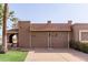 This home features a charming brown two-car garage with decorative windows and a red tile roof at 9837 E Michigan Ave, Sun Lakes, AZ 85248