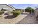 Expansive backyard with rock landscaping, lush greenery, and a covered patio for outdoor enjoyment at 10049 E Topaz Ave, Mesa, AZ 85212