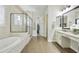 Bright bathroom featuring a soaking tub, glass-enclosed shower, and dual vanities with granite countertops at 10049 E Topaz Ave, Mesa, AZ 85212