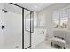 Bright bathroom showcasing the glass-enclosed shower, stylish bathtub, and plantation shutters at 10049 E Topaz Ave, Mesa, AZ 85212
