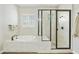 Bright bathroom features a soaking tub and glass-enclosed shower with white tile and wood look flooring at 10049 E Topaz Ave, Mesa, AZ 85212