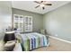 Comfortable bedroom featuring plantation shutters, neutral walls, and a stylish ceiling fan at 10049 E Topaz Ave, Mesa, AZ 85212