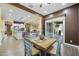 Dining area showcasing a wooden table and blue chairs, situated adjacent to the kitchen and living spaces at 10049 E Topaz Ave, Mesa, AZ 85212