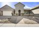 Charming home featuring desert landscaping, a two car garage, and a welcoming entrance, creating inviting curb appeal at 10049 E Topaz Ave, Mesa, AZ 85212
