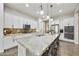 Spacious kitchen with white cabinets, stainless steel appliances, and large granite island with barstool seating at 10049 E Topaz Ave, Mesa, AZ 85212