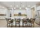 Open kitchen with large island, barstool seating, pendant lights, white cabinets, and stainless steel appliances at 10049 E Topaz Ave, Mesa, AZ 85212