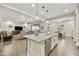 Open concept layout with kitchen island, seating, and a seamless transition into the living and dining areas at 10049 E Topaz Ave, Mesa, AZ 85212