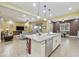 Open-concept kitchen with an island, flowing into living area with a TV, and dining area with table and chairs at 10049 E Topaz Ave, Mesa, AZ 85212