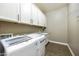 Well-organized laundry room with modern washer and dryer, white cabinets, and countertops at 10049 E Topaz Ave, Mesa, AZ 85212