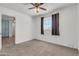 Bright bedroom featuring neutral carpet, a window with gray curtains, and a ceiling fan at 1007 W 5Th St, Mesa, AZ 85201