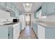 Bright kitchen featuring light blue cabinets, white appliances, and tile flooring at 1007 W 5Th St, Mesa, AZ 85201