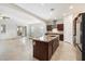 Open-concept kitchen with granite countertops, stainless steel appliances, and dark wood cabinets at 10145 E Cintron Dr, Mesa, AZ 85212