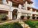 Condo with well-maintained landscaping, stucco siding, and stairs leading to the second floor at 10410 N Cave Creek Rd # 2119, Phoenix, AZ 85020