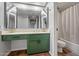 Bright bathroom featuring a green vanity with a undermount sink, large mirror, and a shower-tub combination at 10410 N Cave Creek Rd # 2232, Phoenix, AZ 85020