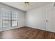 This cozy bedroom features light gray walls, wood floor, window and entry door at 10410 N Cave Creek Rd # 2232, Phoenix, AZ 85020