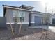 Charming single story home with gray stucco, stone accents, a well kept lawn, and a two-car garage at 10619 W Sonrisas St, Tolleson, AZ 85353