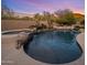Beautiful backyard pool features a spa, waterfall, and lush landscaping with sunset views at 10886 E Ludlow Dr, Scottsdale, AZ 85255