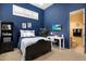 Well-lit bedroom with a dark blue accent wall and a mounted tv at 10886 E Ludlow Dr, Scottsdale, AZ 85255